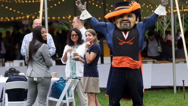 UVA mascot holds hands above head to salute new Darden MBA students on the first day of class 