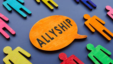 different colored human cutouts around speach bubble that says "allyship"