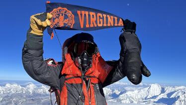 Andrew Katz (Class of 2027) summits Mount Everest holding University of Virginia pennant 